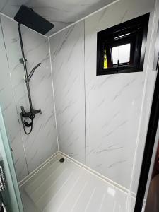 a bathroom with a shower with a window at Tinyhaus 200 in Zadelsdorf +14 photos