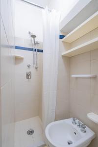 a white bathroom with a shower and a sink at Il Nido - Immersi Nell'arte in Lucca