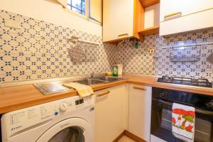 a kitchen with a washing machine and a sink at Il Nido - Immersi Nell'arte in Lucca +4 photos