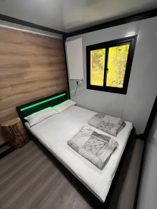 a small bedroom with a bed and a window at Tinyhaus 200 in Zadelsdorf