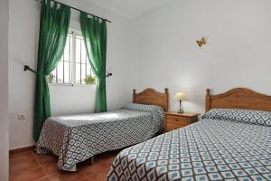 a bedroom with two beds and a window with green curtains at Villa Perez Zara Carmelo in Campano +22 photos