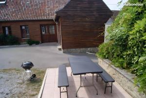 a picnic table and a grill in front of a house at Gite 5 Pers proche Wimereux in Belle-et-Houllefort