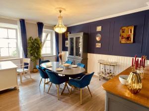 a dining room with blue walls and a table and chairs at Die Residenz in Neidenbach