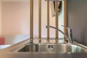 a stainless steel sink in front of a mirror at App. Col Toronn - Ciasa Lavarella in San Vigilio Di Marebbe