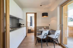a kitchen and dining room with a table and chairs at App. Col Toronn - Ciasa Lavarella in San Vigilio Di Marebbe +9 photos