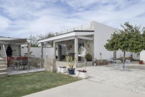 a white house with a patio and a yard at Villa Adán con Piscina Majestuosa in Cádiz