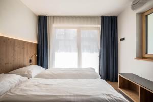 two beds in a bedroom with a window at App. Col Toronn - Ciasa Lavarella in San Vigilio Di Marebbe