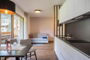 a kitchen with a table and a dining room at App. Col Toronn - Ciasa Lavarella in San Vigilio Di Marebbe