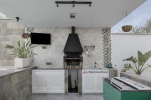a kitchen with white cabinets and a stove at Villa Adán con Piscina Majestuosa in Cádiz