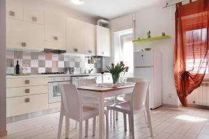 a white kitchen with a table and chairs at Mariva in Germignaga