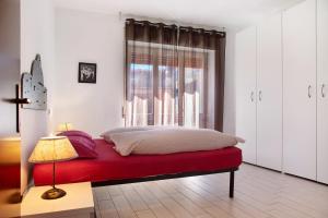 a bedroom with a red bed with a window at Mariva in Germignaga