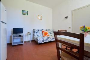 a living room with a chair and a tv at Mare Etrusco 5 in Populonia