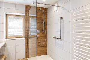 a shower with a glass door in a bathroom at Ferienwohnung Pfeffer in Leogang +18 photos