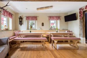 a living room with tables and benches and windows at Stub'n Herbert in Waischenfeld