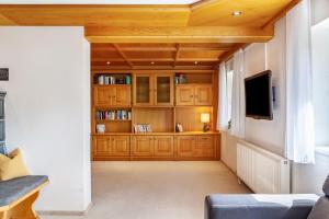 a living room with wooden cabinets and a flat screen tv at Ferienwohnung Pfeffer in Leogang