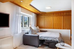 a bedroom with a bed and a chair and a window at Ferienwohnung Pfeffer in Leogang