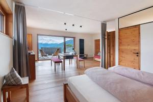 a bedroom with a bed and a dining room at Ansitz Röfen in Burgusio