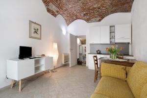 a living room with a couch and a kitchen at Ciliegio Agriturismo La Ferla in Toirano