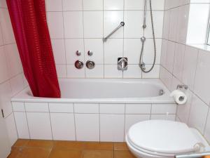 a bathroom with a toilet and a tub with a shower at Ferienwohnung Koch Thurgauer Weg in Reichenau
