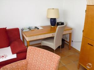 a desk with a chair and a table with a lamp at Ferienwohnung Koch Thurgauer Weg in Reichenau