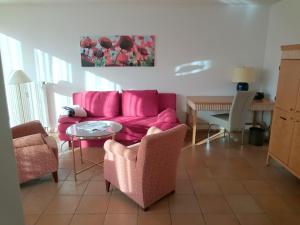 a living room with a pink couch and a table at Ferienwohnung Koch Thurgauer Weg in Reichenau