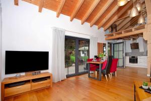 a living room with a television and a table with chairs at Schorenmoos Lodge in Dietmannsried