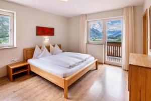 a bedroom with a bed and two windows at Niedermaierhof in Kastelbell-Tschars