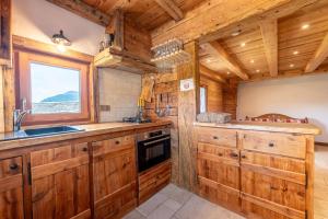 a kitchen with wooden cabinets and a window at Gite Les Clapières in La Giettaz +51 photos