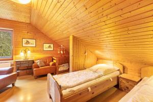 a bedroom with a bed in a wooden room at Blockhaus Marie in Frielendorf