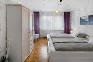 two beds in a bedroom with purple curtains at Ferienappartment Becker Zentrum in Lauterbach