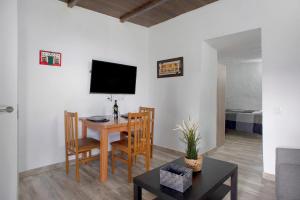 a living room with a table and a television at Ca' Navarro in Vega de San Mateo