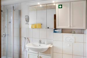 a white bathroom with a sink and a shower at Ferienappartment Becker Zentrum in Lauterbach +13 photos