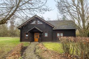 a wooden house with a yellow door in a yard at Blockhaus Marie in Frielendorf