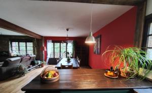 a living room with a wooden table and red walls at Casa Rural el Bac in Castellar de NʼHug