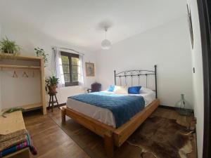 a bedroom with a bed with a blue comforter at Casa Rural el Bac in Castellar de NʼHug