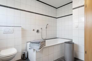 a white bathroom with a tub and a toilet at Ferienwohnung in Spelle in Spelle +18 photos