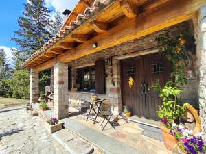 a stone house with a wooden door and a table at Casa Rural el Bac in Castellar de NʼHug