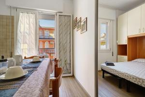 a room with a table and a bed and a window at Villa Trentina in Lido di Jesolo