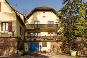 a white house with a balcony on top of it at Bienvenue-Willkommen in Boersch