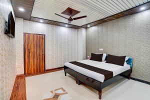 a bedroom with a bed and a ceiling fan at Hotel O NICE HOTEL in Faridabad