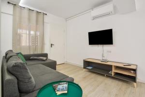 a living room with a couch and a flat screen tv at Las Américas Seafront - Free Wi-fi in Playa de las Americas