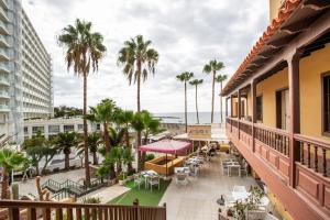 a balcony with a view of the beach and palm trees at Las Américas Seafront - Free Wi-fi in Playa de las Americas