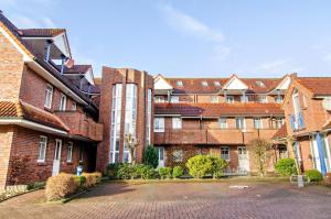 a group of brick apartment buildings with a parking lot at Ferienwohnung Boje 20 in Schillig