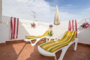 a group of chairs and an umbrella on a patio at Apartment Nieves 2 in Nerja