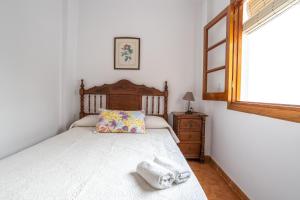 a bedroom with a bed with a wooden headboard and a window at Apartment Nieves 2 in Nerja