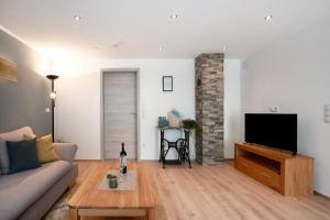 a living room with a couch and a flat screen tv at Ferienwohnung Birke in Altusried
