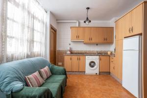 a living room with a green couch in a kitchen at Apartment Nieves 2 in Nerja