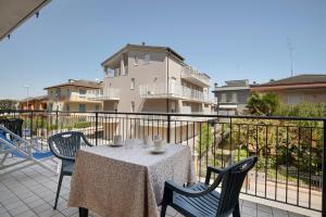 a table and chairs on a balcony with a building at Villa Trentina in Lido di Jesolo