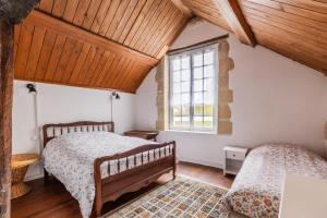 a bedroom with two beds and a window at La maison blanche in Nazelles