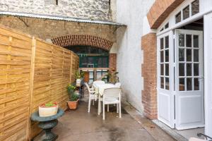 a patio with a table and chairs and a door at La maison blanche in Nazelles